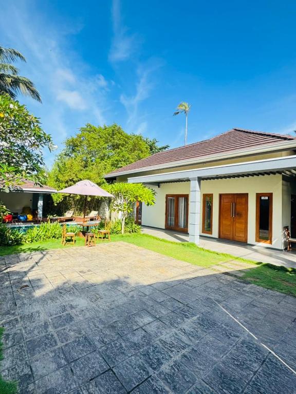 a house with a patio with a table and chairs at Moana La Vie - Polhena in Matara
