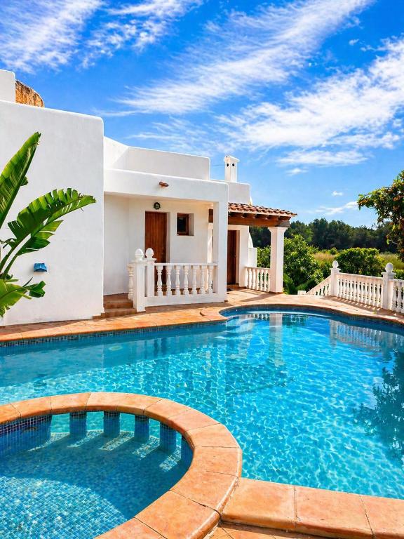 a villa with a swimming pool in front of a house at Excelente villa With pool ibiza in Santa Gertrudis de Fruitera