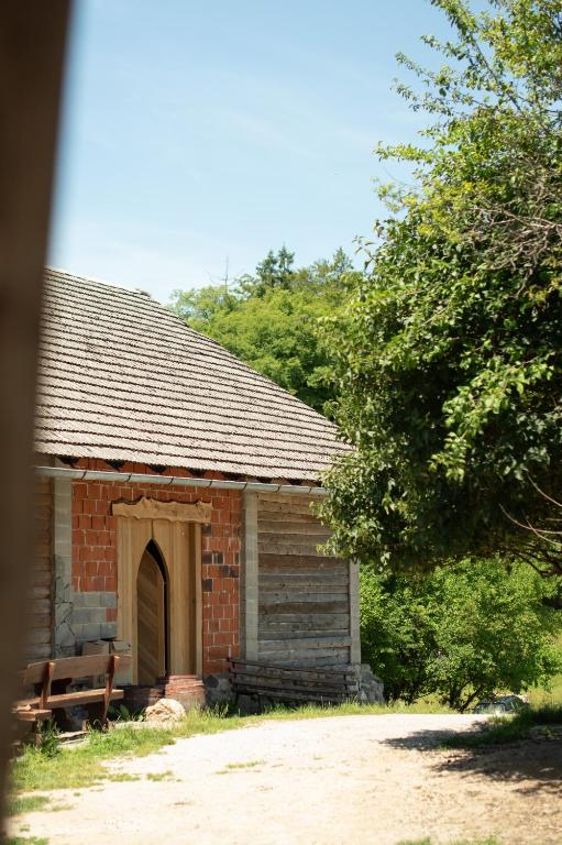 a brick building with a bench in front of it at Bungalow Volk Turjaški in Gabrovka
