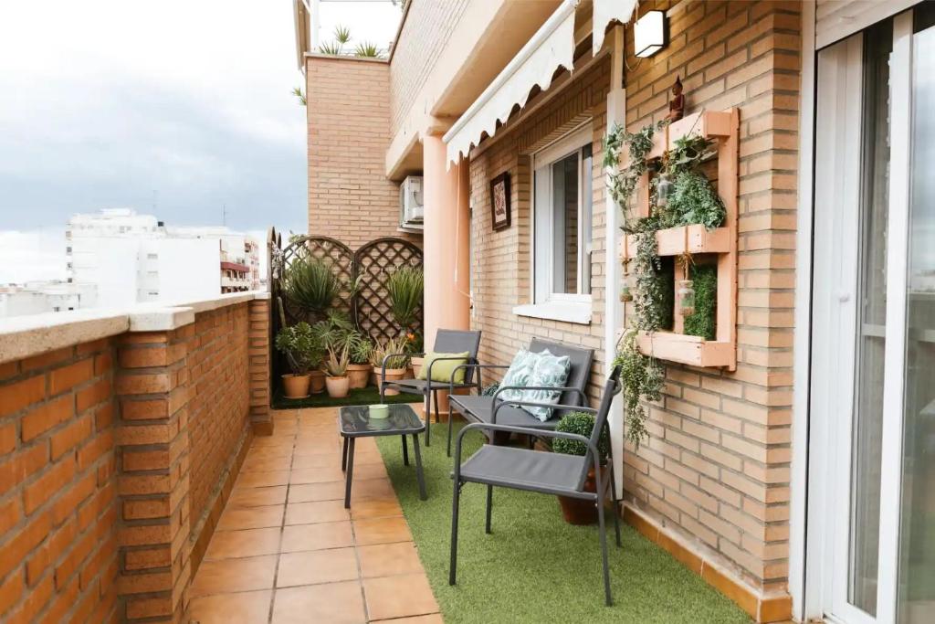 a small balcony with chairs and a table at Encalma vacacional El Ático, terraza,garaje,playa in Puerto de Sagunto