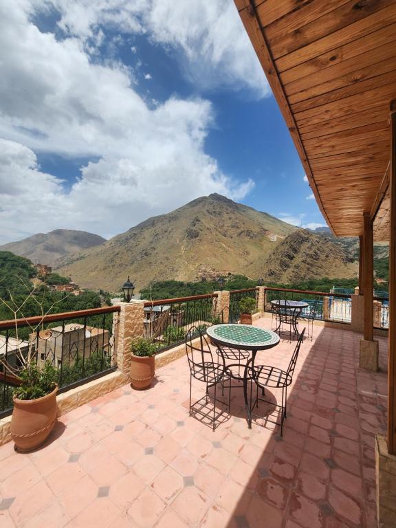 a patio with tables and chairs and a mountain at Azul Atlas Lodge in Imlil