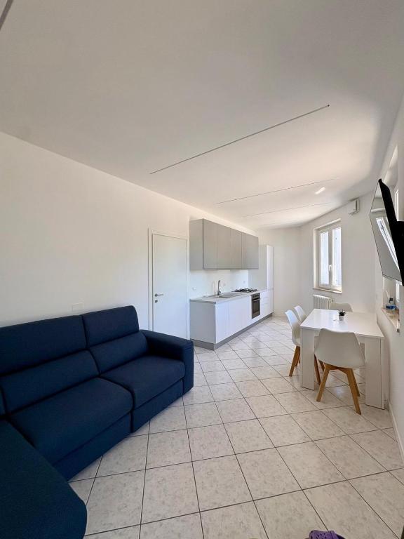 a living room with a blue couch and a kitchen at Mas de le Contesse in Ton