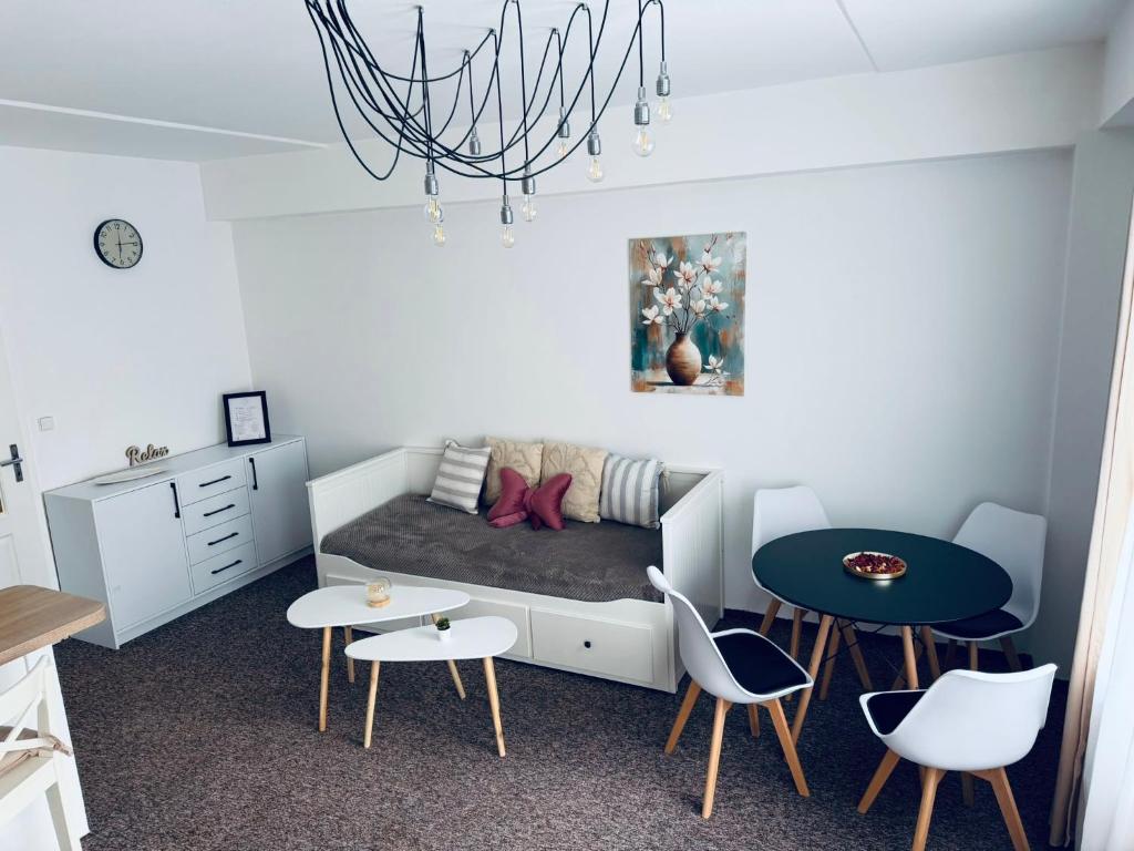 a small room with a bed and a table and chairs at Apart Aurum B&M in Jáchymov