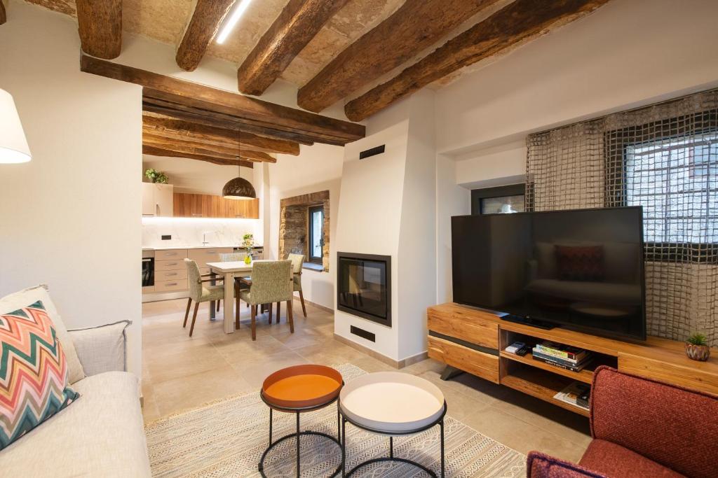 a living room with a large television and a table at Cannn Patllari de Corts I II in Cornellá de Terri