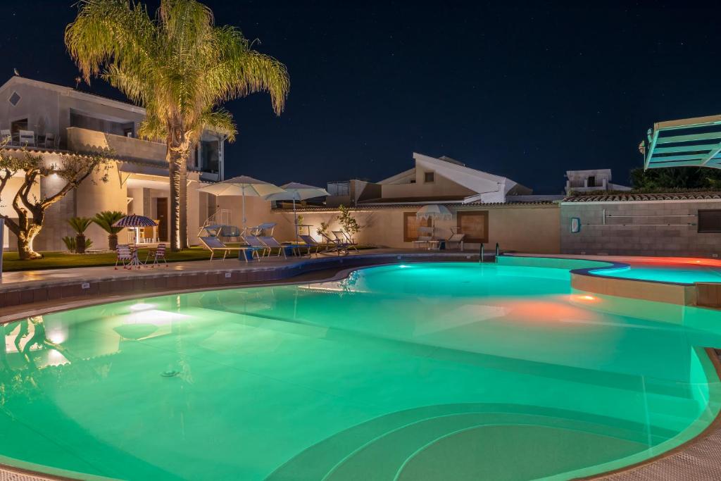 a swimming pool at night with a villa at Aqua Suites Doria in Syracuse