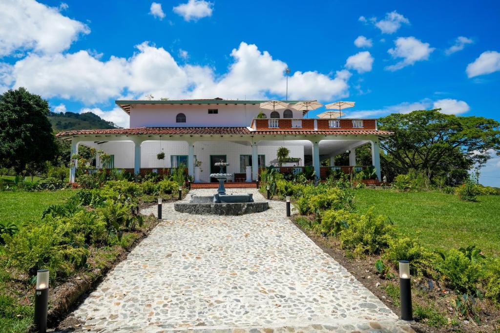 a white house with a pathway in front of it at Alma Terra Campestre in Ginebra