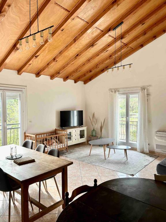 a living room with a table and a tv at Large Family Chalet Mountain Views in Olette