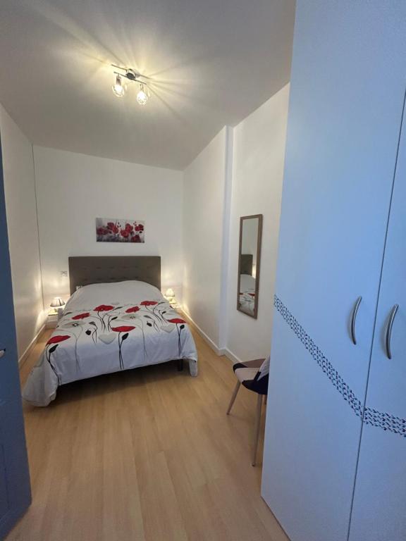 a bedroom with a bed in a white room at Appartement 5 - T2 Meublé 2 étoiles proche des thermes in Vals-les-Bains