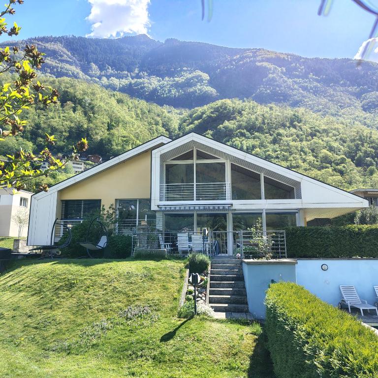 a house with a mountain in the background at BluVilla in Malvaglia