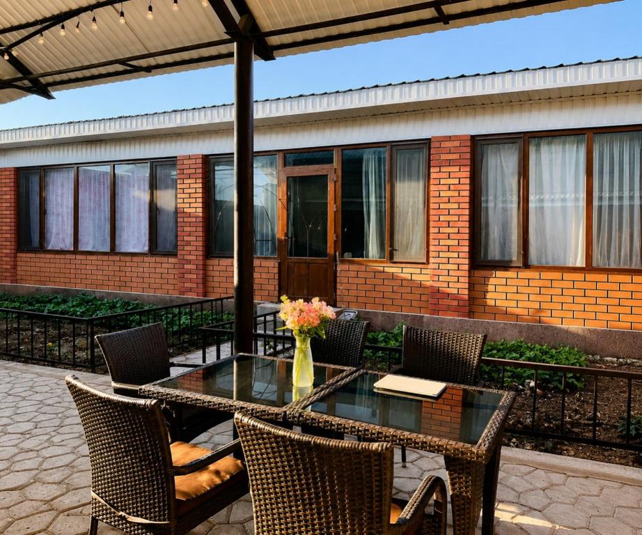 a table with chairs and a vase of flowers on a patio at Дом у Озера in Priozersk