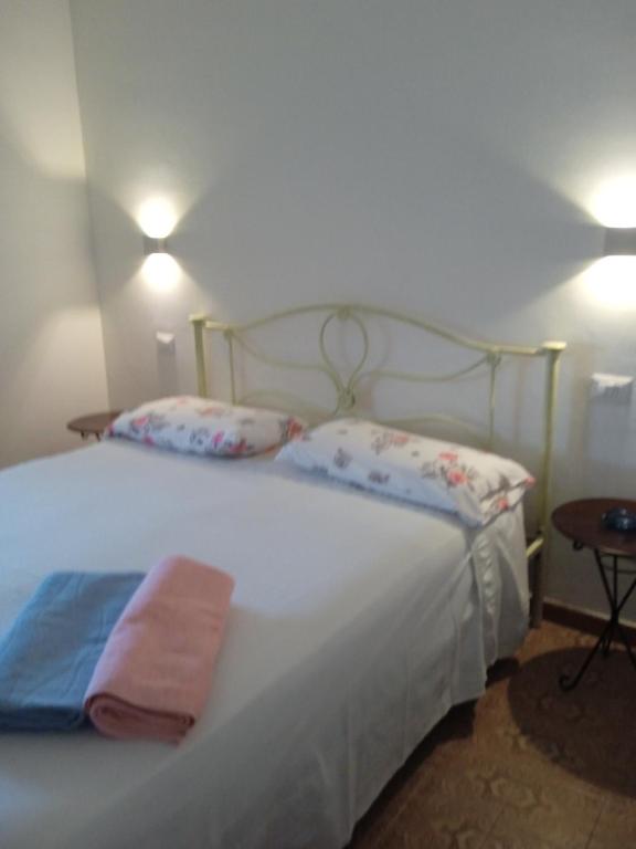 ein Schlafzimmer mit einem großen weißen Bett und zwei Kissen in der Unterkunft Casa Sofia in Palinuro
