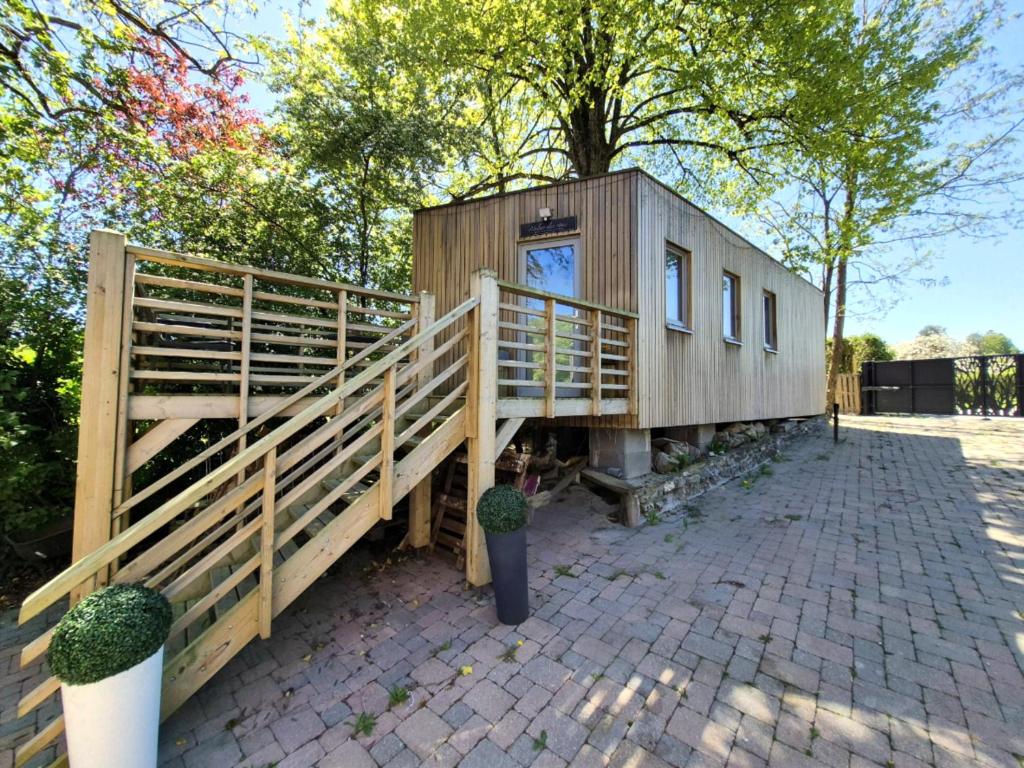 a small wooden house with a wooden fence at Tiny House Chimay in Chimay