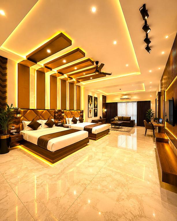 a bedroom with two beds and a living room at Premium Hotel EXO-Near Temple and Ghat#Parking and Comfort Stay#Premium Service in Varanasi