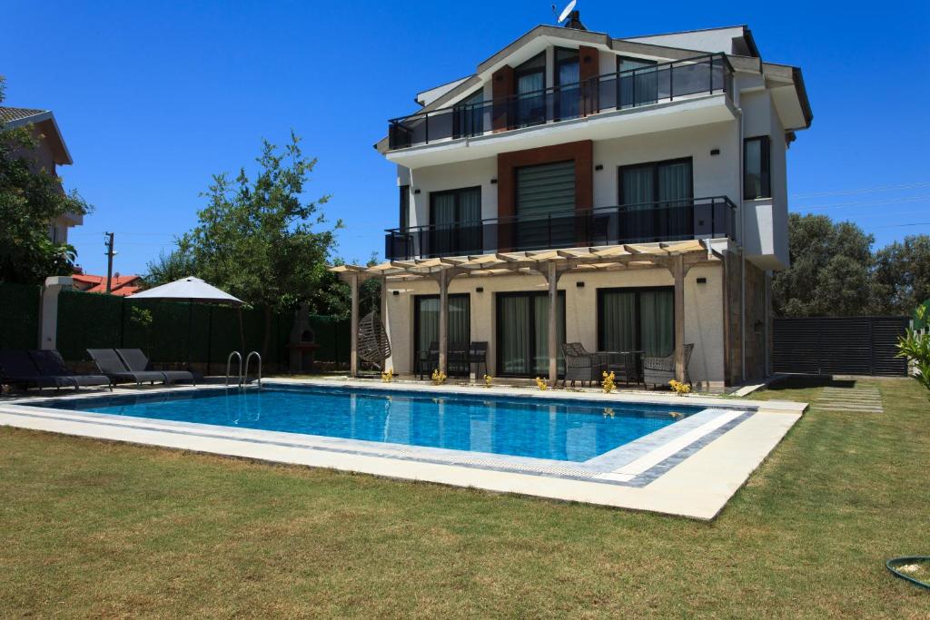 a villa with a swimming pool in front of a house at Cesur Villa 2 in Fethiye