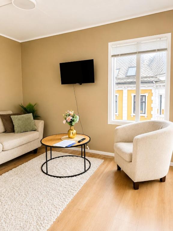 a living room with a couch and a table and a tv at Barfot Apartment - Bergen City center in Bergen