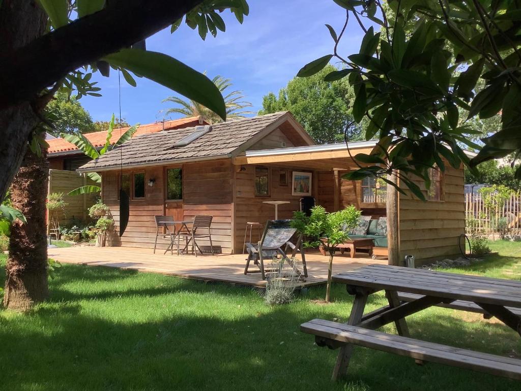 a log cabin with a picnic table in the yard at La Crampotte de Bidart, proche Océan in Bidart