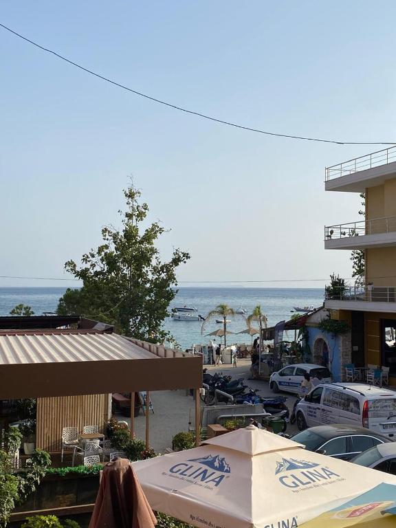 a beach with tables and umbrellas and the ocean at Spacious-Central Apartment in Himare