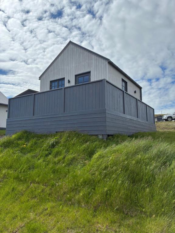 a large building on top of a grassy hill at Akrar guesthouse in Hella