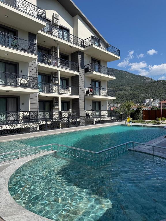 a large swimming pool in front of a building at Fethiye Serenity Suites in Fethiye