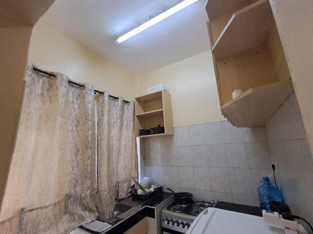 a small kitchen with a sink and a stove at Utele Cottages in Thika