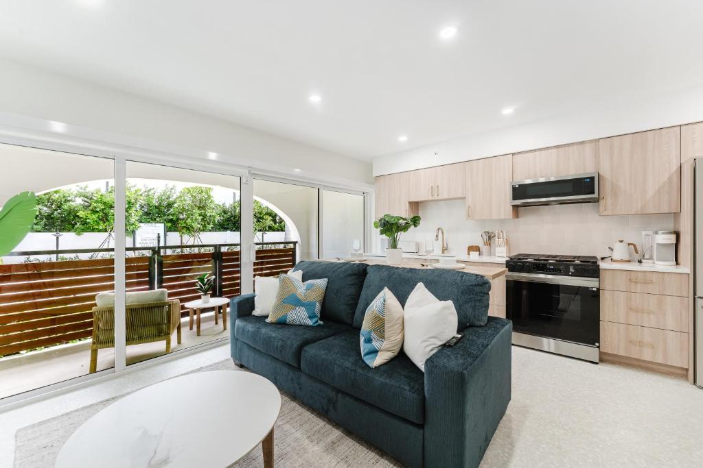 a living room with a blue couch and a kitchen at Villa Solana - Boca Pool Hideaway in Boca Raton