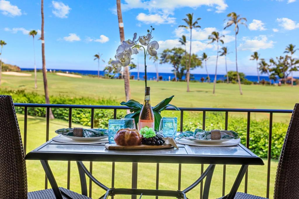 a table with food and a bottle of wine at Maui Eldorado Condo J221 in Kaanapali
