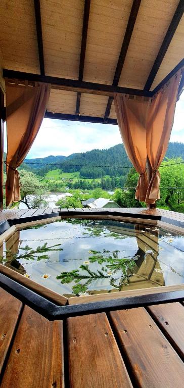 a glass table on a wooden deck with a view at Садиба Грицюка in Krivorovnya