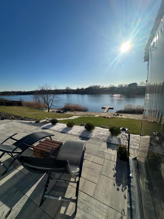a chair on a patio with a view of a lake at Słoneczny Pagórek in Żałe