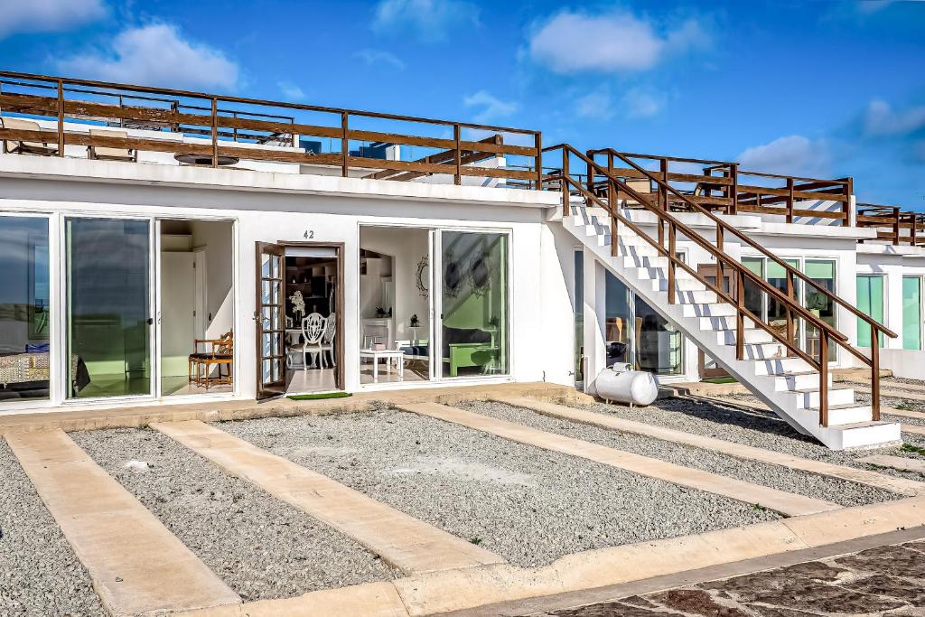a house with a staircase on top of it at Dog-Friendly Oceanfront Villa with Rooftop Patio, Pool Access, & Kitchen in Rosarito