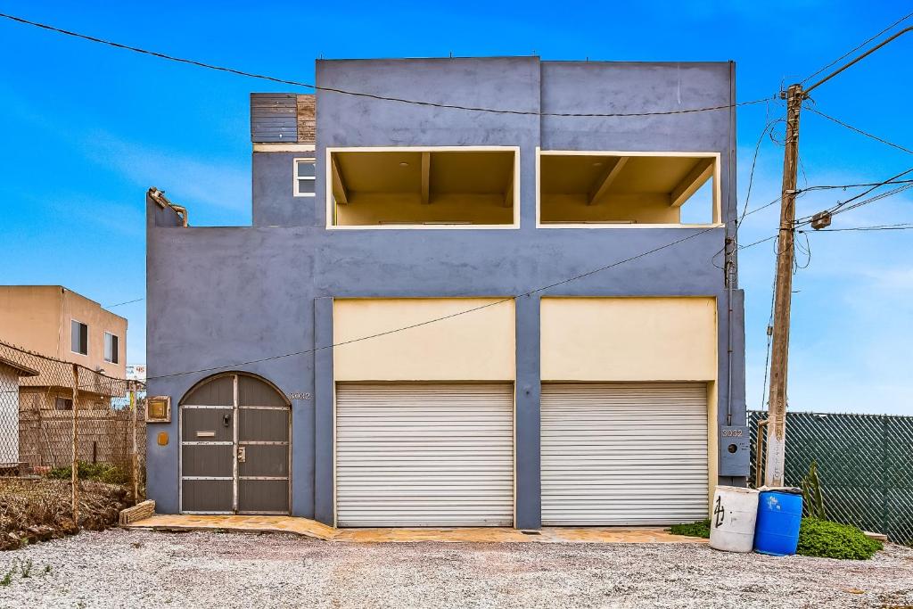 a building with two garage doors in front of it at Tropical Retreat with Ocean Views - Steps from the sand with alfresco dining in Rosarito