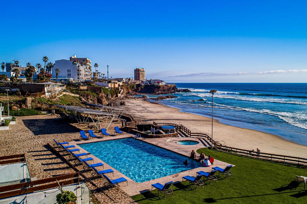 a swimming pool next to a beach and the ocean at Bright Dog-Friendly Villa with Beach Views, Private Patio, Outdoor Pool, Kitchen in Rosarito