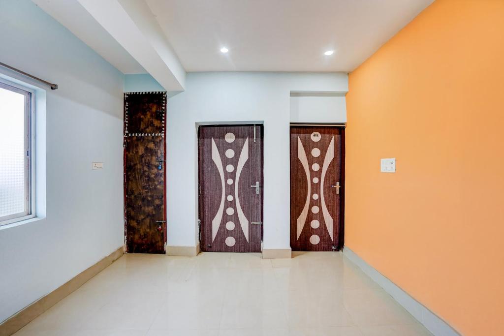 two doors in a room with orange and white walls at Hotel O Royal Inn Hotel in Dīgha