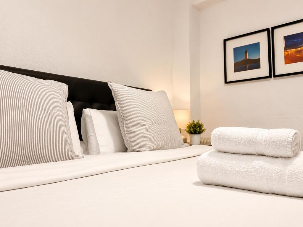 a white bed with white pillows in a room at Centrico apartamento en Leganes in Leganés