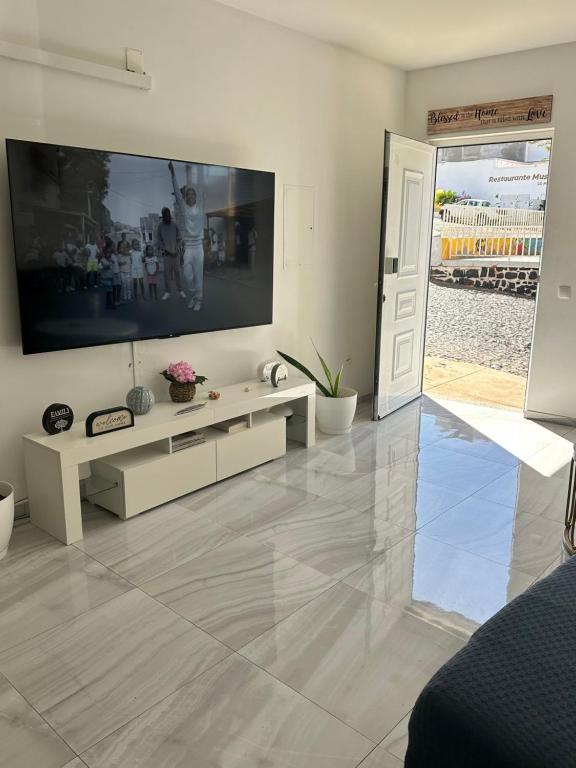 a living room with a large flat screen tv on the wall at Coraçon di Mindel Apartment in Mindelo