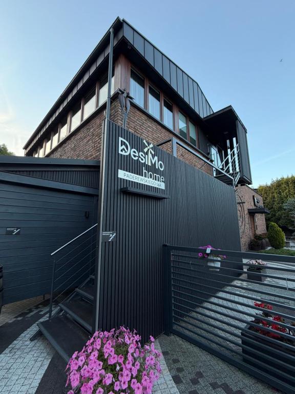 a building with a sign on the side of it at Desimo Home in Piła