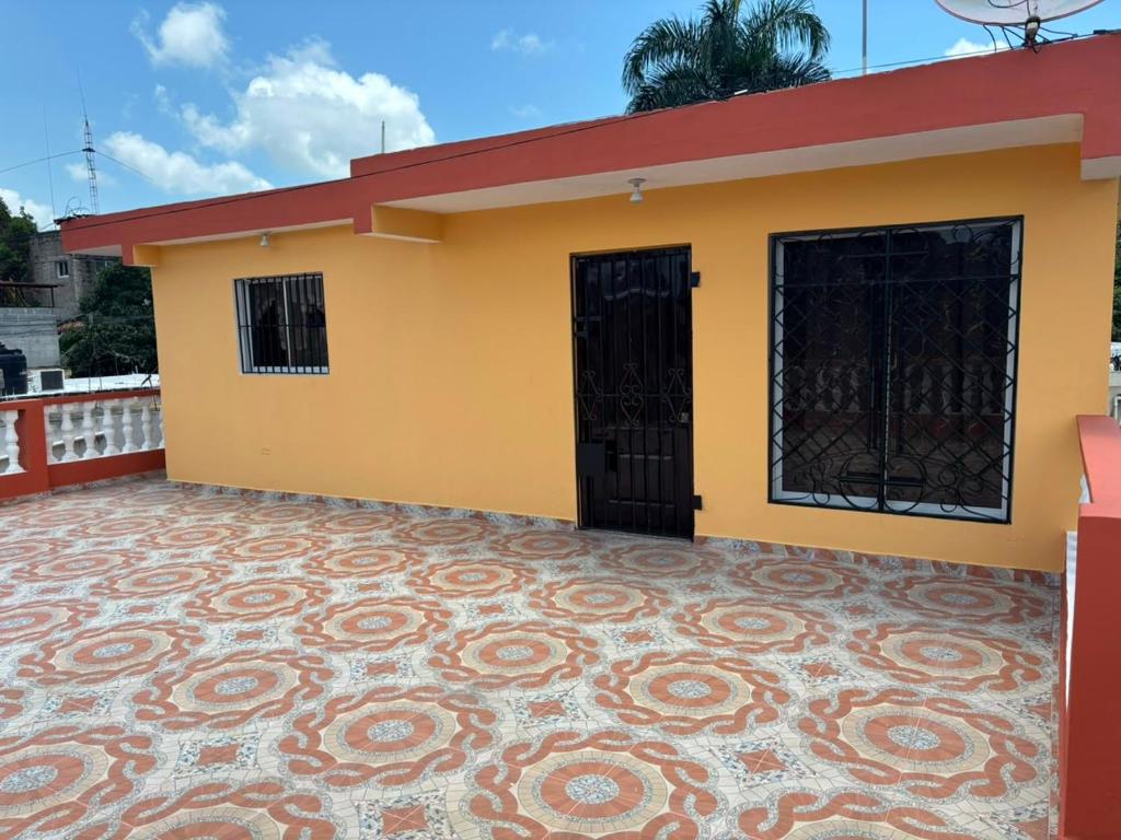 a yellow house with a red roof at Terraza Marina in Bajos de Haina
