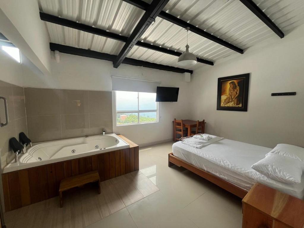a bedroom with a bed and a bath tub at Hotel Cerro Bravo in Fredonia
