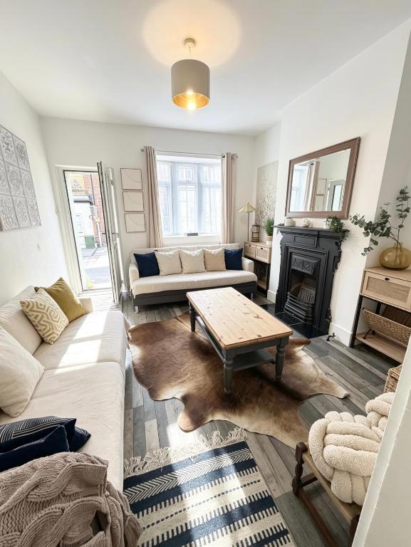 a living room with a couch and a table at Summerfields cottage stylish Home in Hollington