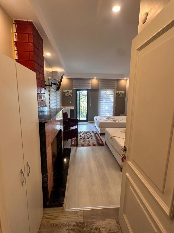 a room with two beds and a room with a door at Lotus 4 Mevsim Otel in Ayvalık