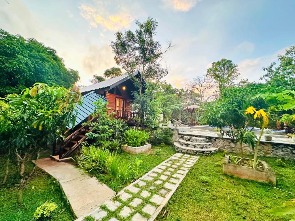 a garden with a house and a pathway at Mango Garden Eco Resort sigiriya in Sigiriya