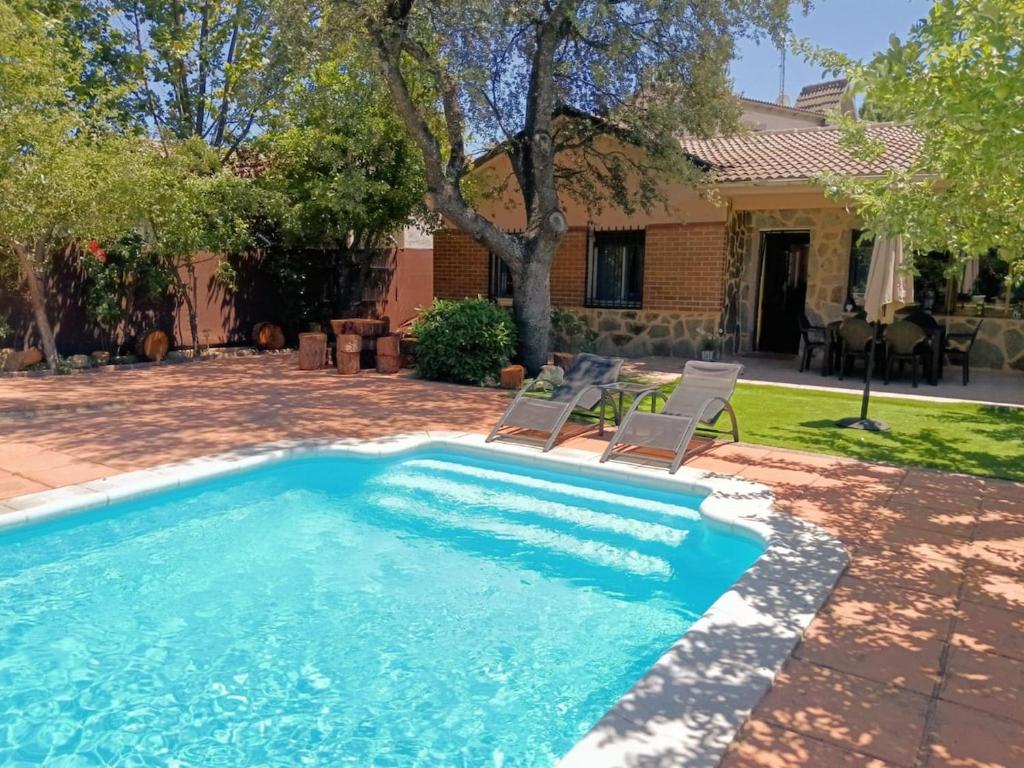 a swimming pool with two chairs and a house at montepino 2 in Maello