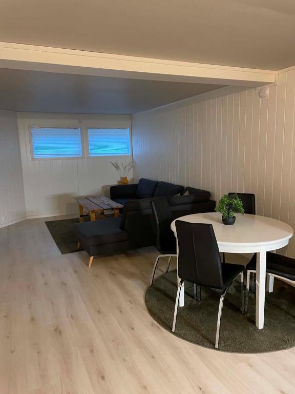 a living room with a table and a couch at Modern basement apartment, 65 square meters in Alta