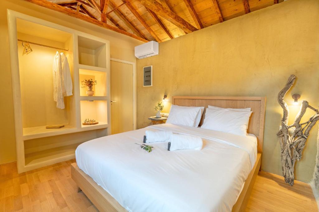 a bedroom with a large white bed in a room at Melias Olive Retreat in Kelefá