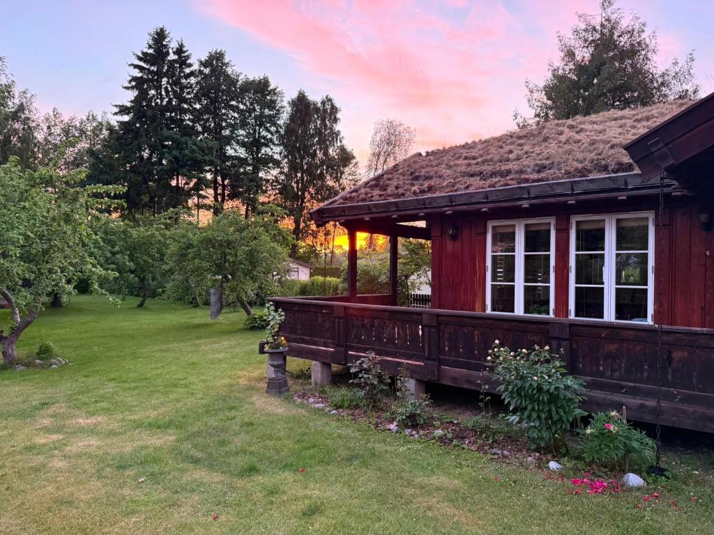 a red house with a porch in a yard at Golden Seaside Villa in Kärdla
