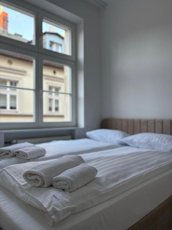 a bed with towels on it with a window at Amulet Poznan Old Town in Poznań