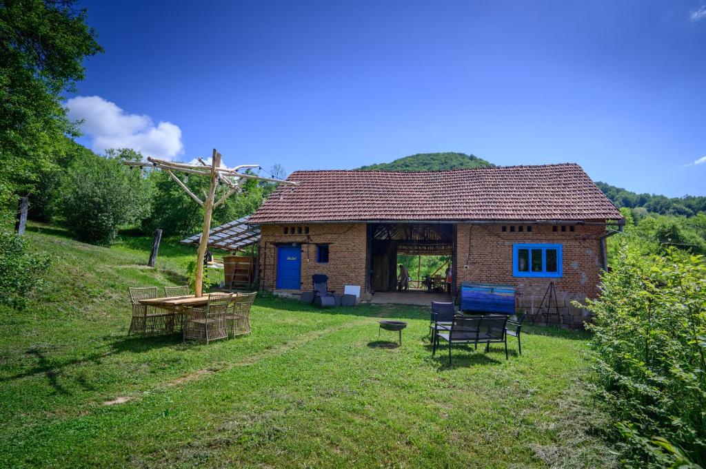 ein kleines Backsteinhaus in einem grasbewachsenen Hof in der Unterkunft Camping OR in Bucureşci