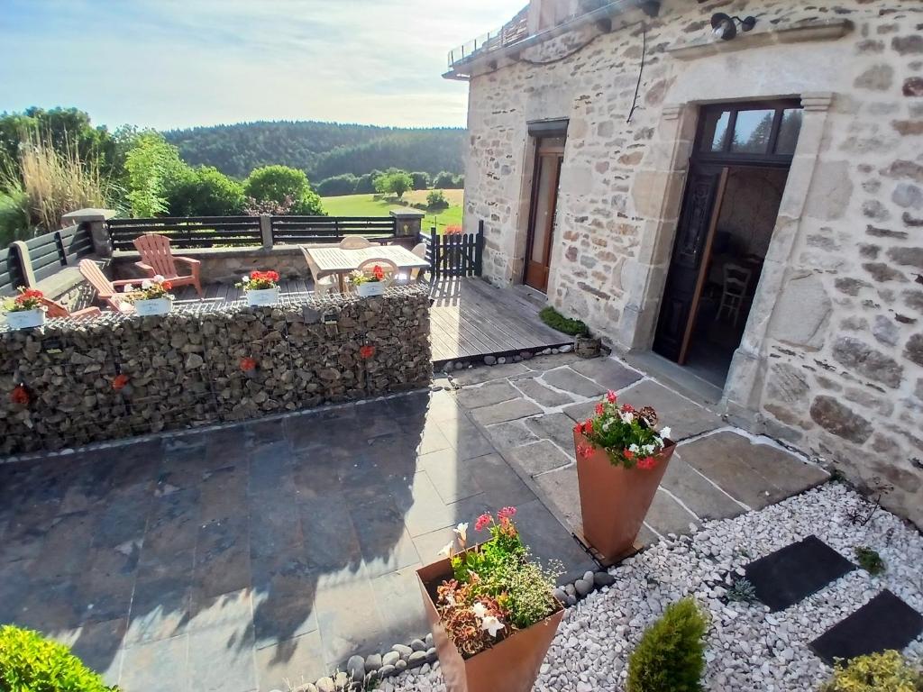 a view of a stone house with a patio at La Maison de Valie in Mercoeur