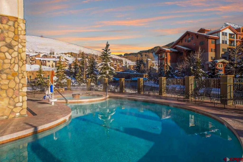 a large swimming pool in a resort with a mountain at 1bd 272 Perfect Location with Pool in Crested Butte