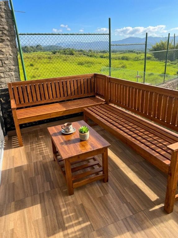 a wooden bench and a table on a balcony at SSR Wasana in Sita Eliya