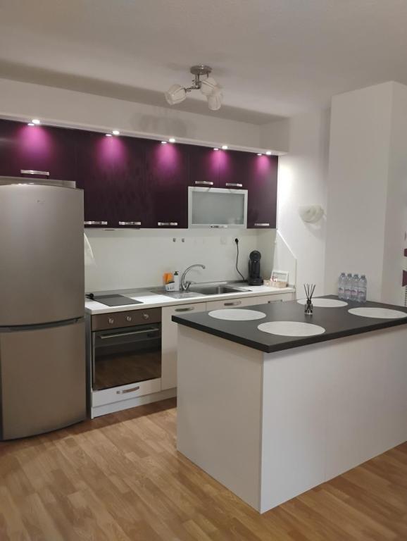 a kitchen with white appliances and purple lights on the wall at STADIUM 1 Apartments Sandanski in Sandanski